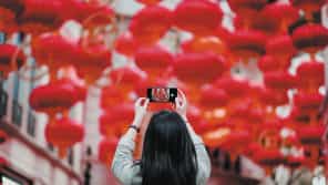 Chica echando fotos a unos farolillos rojos